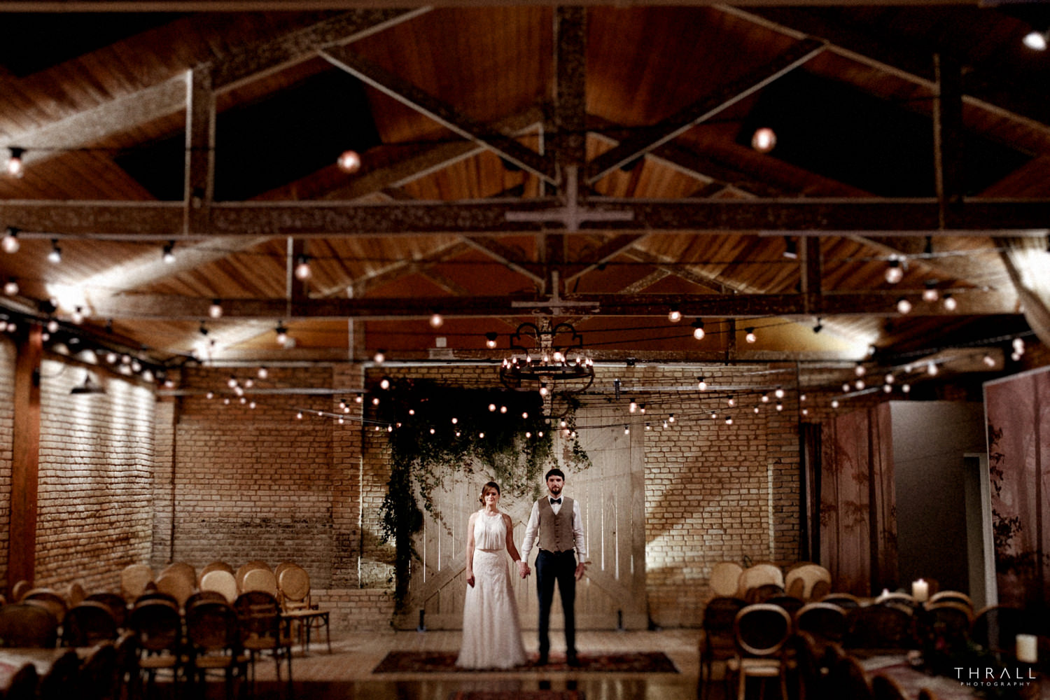 noivos de mãos dadas numa sala com teto de madeira estilo rústico chic