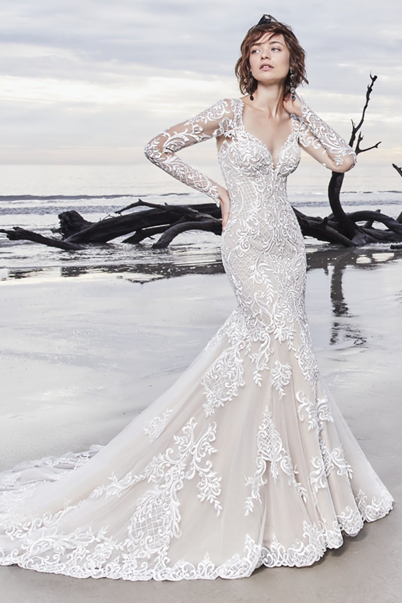 <a href="https://www.maggiesottero.com/sottero-and-midgley/dakota/11529">Maggie Sottero</a>
Lindos motivos de renda em cascata sobre tule proporcionam elegância a este vestido de noiva, finalizado com mangas compridas ilusão, decote V e decote ilusão na parte posterior.