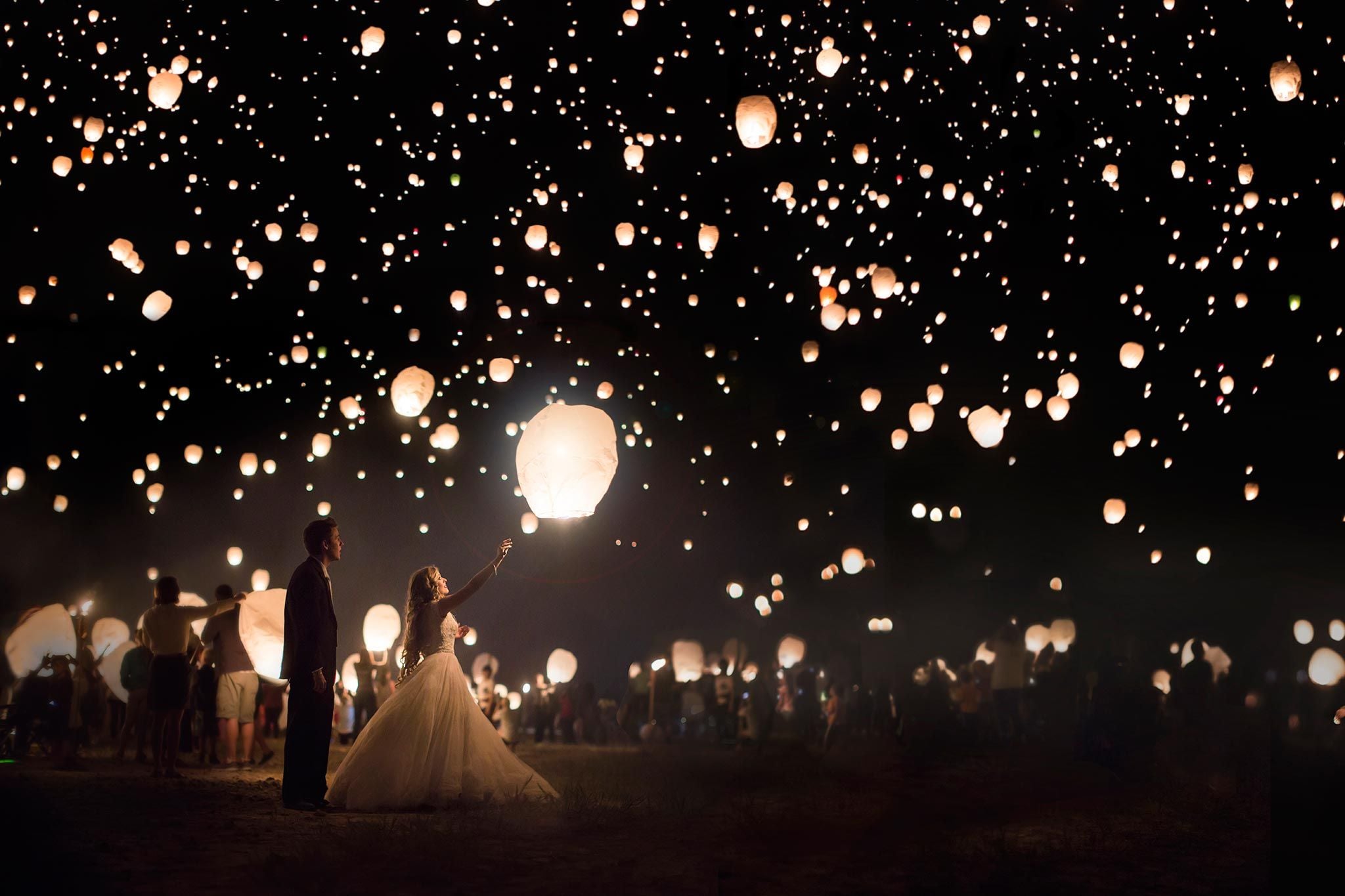 noivos e convidados lanternas chinesas no céu noite escura