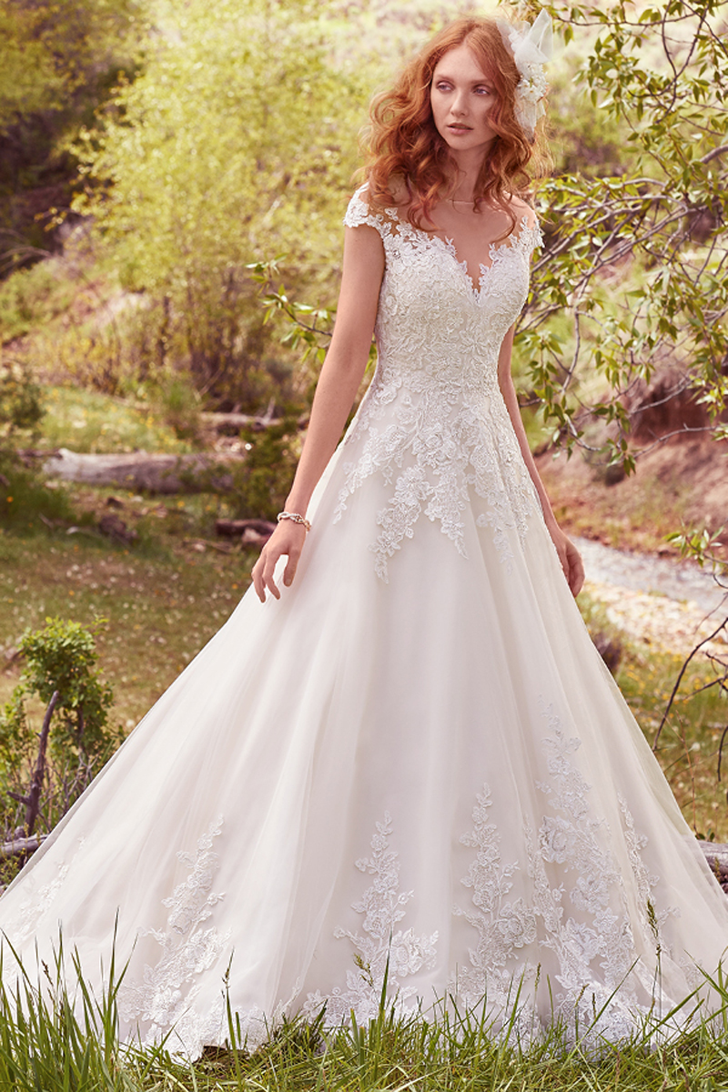 Este vestido com efeito balão apresenta pormenore de renda ao longo do corpete com um decote em forma de coração. Com detalhes cruzados subtis enquanto que as lantejoulas conferem dimensão e brilho. Terminado com botões na zona do fecho, incluindo, também, um fecho interior.
<a href="https://www.maggiesottero.com/maggie-sottero/lena/10120?utm_source=mywedding.com&utm_campaign=spring17&utm_medium=gallery" target="_blank">Maggie Sottero</a>Terminado com botões e com um fecho.