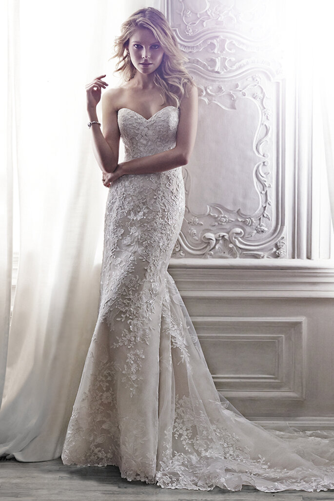 Vestido de noiva elegante com um clássico decote coração e aplicações de renda floral. Acabamento com fecho no corpete interior e botões de cristal sobre o zipper.
<a href="http://www.maggiesottero.com/dress.aspx?style=5MS146LU" target="_blank">Maggie Sottero Spring 2015</a>