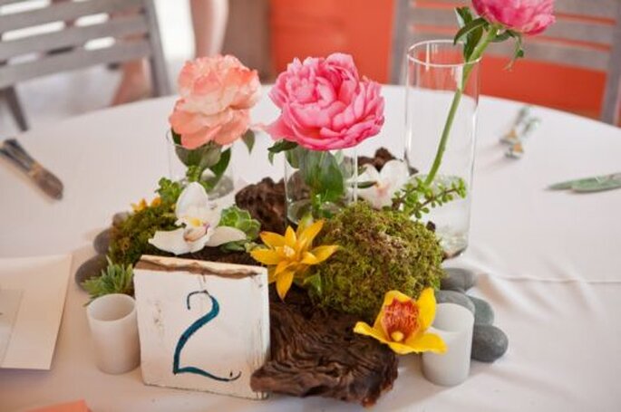 Os centros de mesa estavam compostos por flores rosa e laranja.