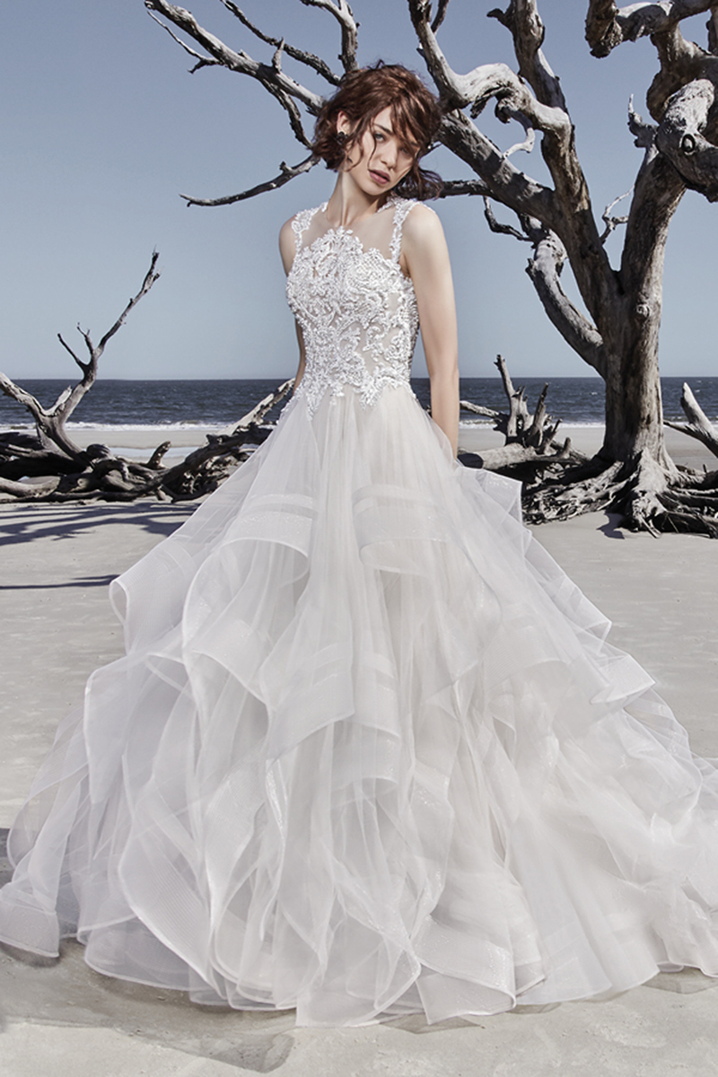 Este moderno vestido de noiva princesa apresenta um corpete de renda, realçado com cristais Swarovski. A saia, confecionada com tule que apresenta, igualmente, pormenores rendados que completam a ideia de um colar de joias, assim como o decote das costas. Terminado com botões de cristais e um fecho.
<a href="https://www.maggiesottero.com/sottero-and-midgley/ariya/11516">Sottero and Midgley</a>