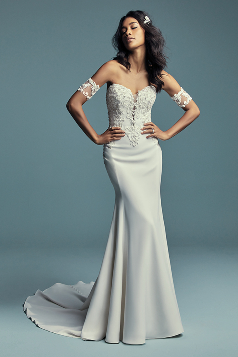 <a href="https://www.maggiesottero.com/maggie-sottero/kimbra/11490">Maggie Sottero</a>
Vestido de noiva fit-and-flare que apresenta pormenores rendados. Terminado com um fecho sobre um espartilho elástico. Botões de pérolas.
