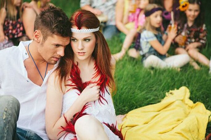 Noivos sentados sobre a manta de piquenique junto aos convidados. Foto: Bell Studio.