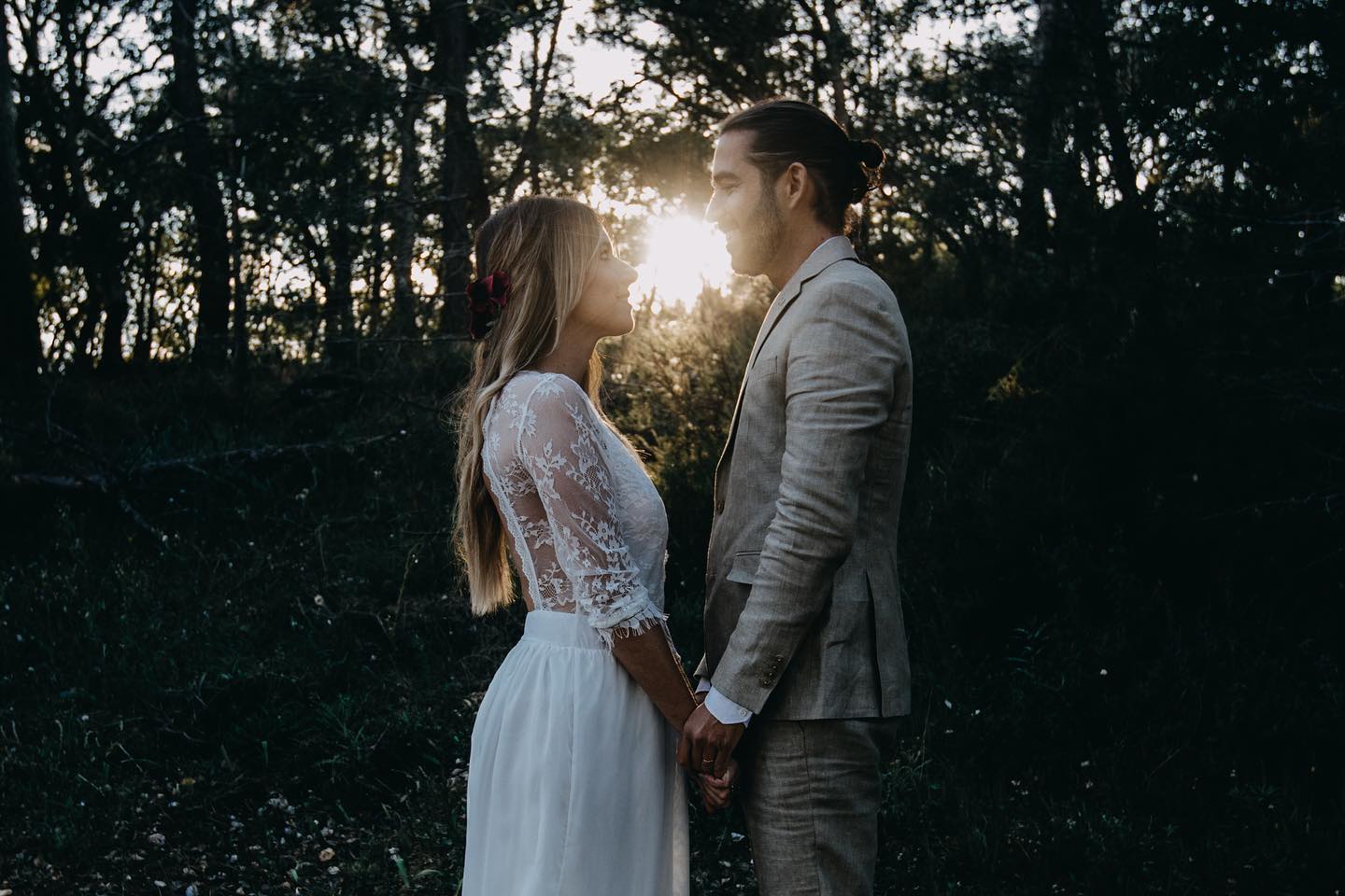 casal de noivos de mãos dadas ao por-do-sol