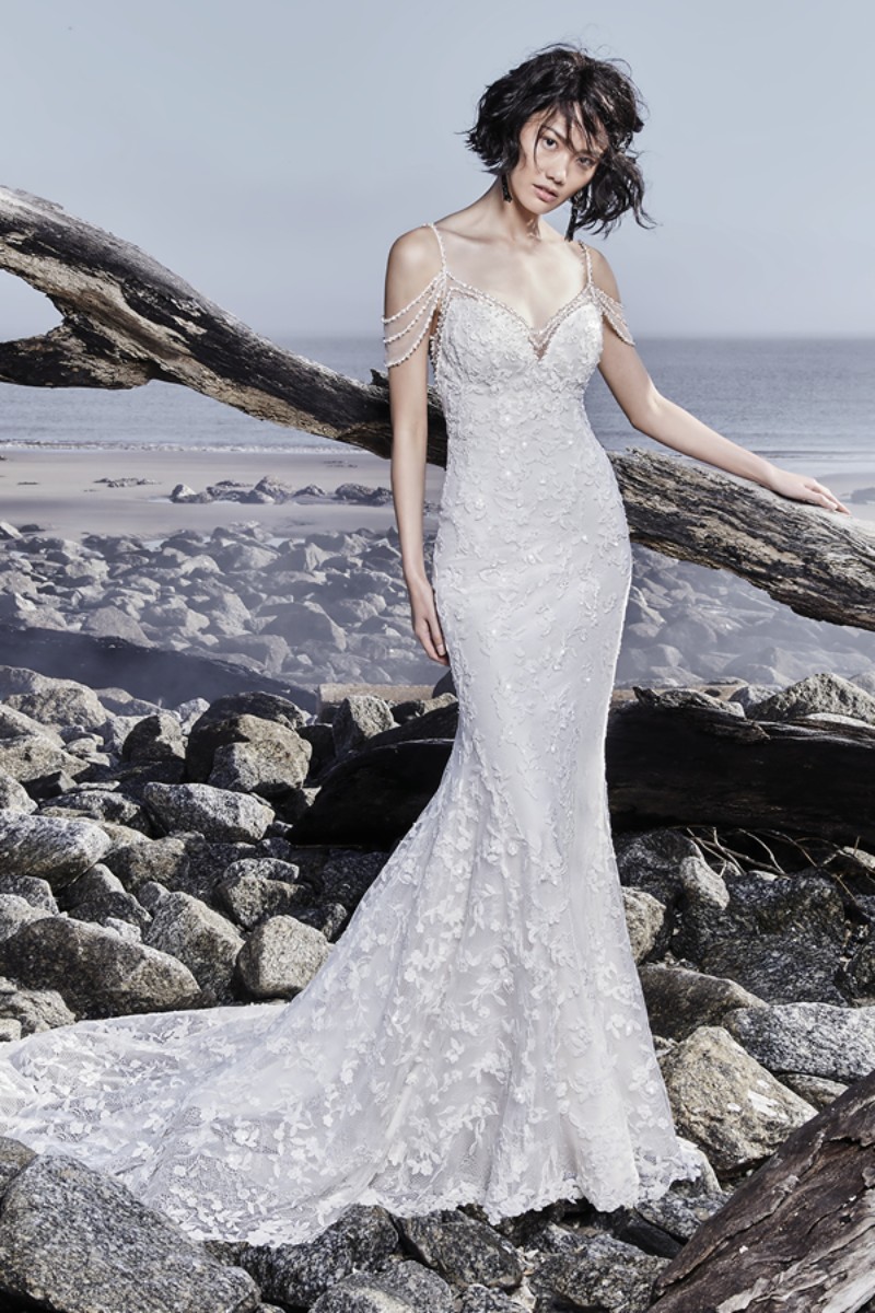 <a href="https://www.maggiesottero.com/sottero-and-midgley/lynnis/11550">Maggie Sottero</a>
Pequenos detalhes flutuam sobre a renda e York jersey que compõem este vestido de noiva sereia estilo boho, finalizado por uma belíssima cauda ilusão.