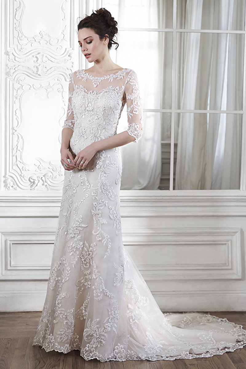 A dramatic illusion lace back and illusion sleeves adorn this hand-embellished sheath gown, glimmering with metallic lace appliqués and embroidered with Swarovski crystals drifting from shoulder to floor-skimming hem. A delicate scalloped hemline completes the look. Finished with pearl button over zipper back closure.
<a href="http://www.maggiesottero.com/dress.aspx?style=5MW113&page=0&pageSize=36&keywordText=&keywordType=All" target="_blank">Maggie Sottero</a>