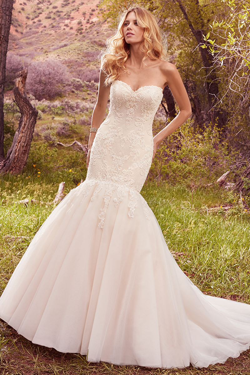 Detalhes em renda decoram o tule cruzado no corpete caracterizam este vestido fit-and-flare de um verdadeiro conto de fadas. Com botões e um fecho interior. Mangas curtas removíveis com pormenores em renda vendidas separadamente.
<a href="https://www.maggiesottero.com/maggie-sottero/keely/10111?utm_source=mywedding.com&utm_campaign=spring17&utm_medium=gallery" target="_blank">Maggie Sottero</a>