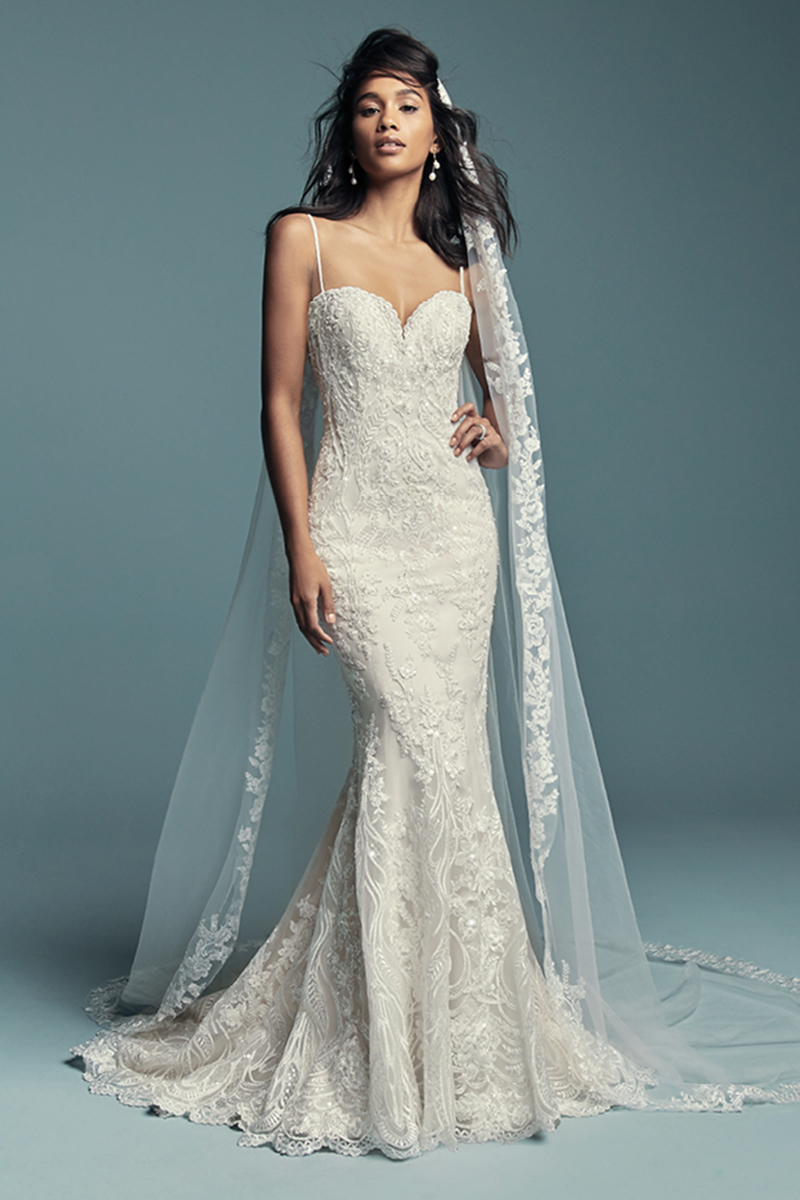 <a href="https://www.maggiesottero.com/maggie-sottero/gwendolyn/11479">Maggie Sottero</a>

Bordados de renda caem em cascata ao longo do tule que constitui este sexy vestido de noiva fit-and-flare, com um decote em forma de coração e alças finas. Terminado com botões sobre um fecho e um espartilho interior. Véu com pormenores de renda que pode ser retirado é vendido separadamente.