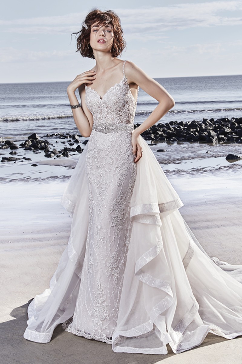 <a href="https://www.maggiesottero.com/sottero-and-midgley/marcelle/11553">Maggie Sottero</a>
Detalhes em renda finalizam o tule que desce em em cascata neste vestido de casamento. O decote nas costas ganha tiras compostas por contas proporcionando um aspecto encantador.