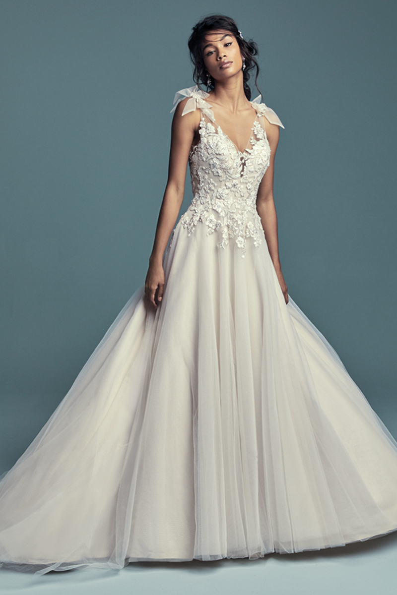 <a href="https://www.maggiesottero.com/maggie-sottero/farron/11473">Maggie Sottero</a>
Bordado com pormenores de rendas e com cristais de Swarovski dançam ao longo do body deste romântico vestido de noiva linha. Saia com várias camadas confecionadas com tule. Terminado com botões cobertos sobre um fecho.