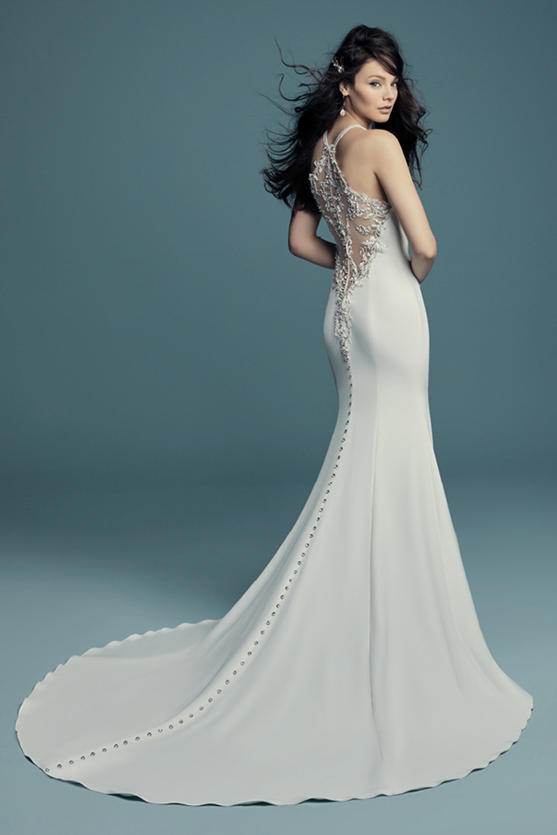 <a href="https://www.maggiesottero.com/maggie-sottero/maurelle/11496">Maggie Sottero</a>
Cristais Swarovski e pormenores de renda bordados caem em cascata ao longo do profundo decote halter com efeito ilusão: assim pode ser descrito este incrível vestido de noiva. Botões de cristal.