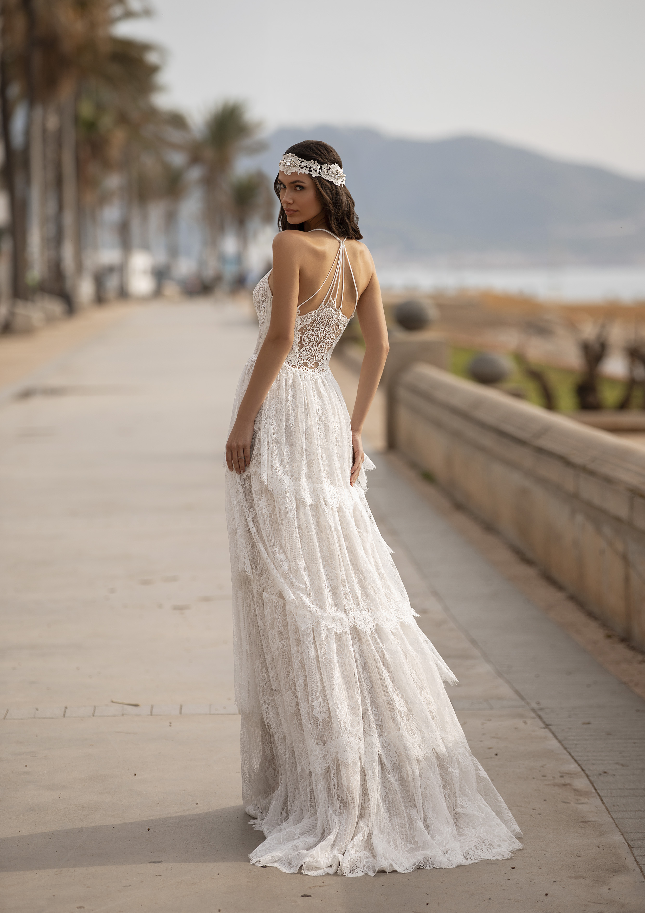 Vestido com toque de romantismo boémio, com camadas de renda em cascata, corpo inspirado em lingerie e delicadas alças cruzadas com pedraria. | Modelo Grahame Pronovias 2021 Cruise Collection