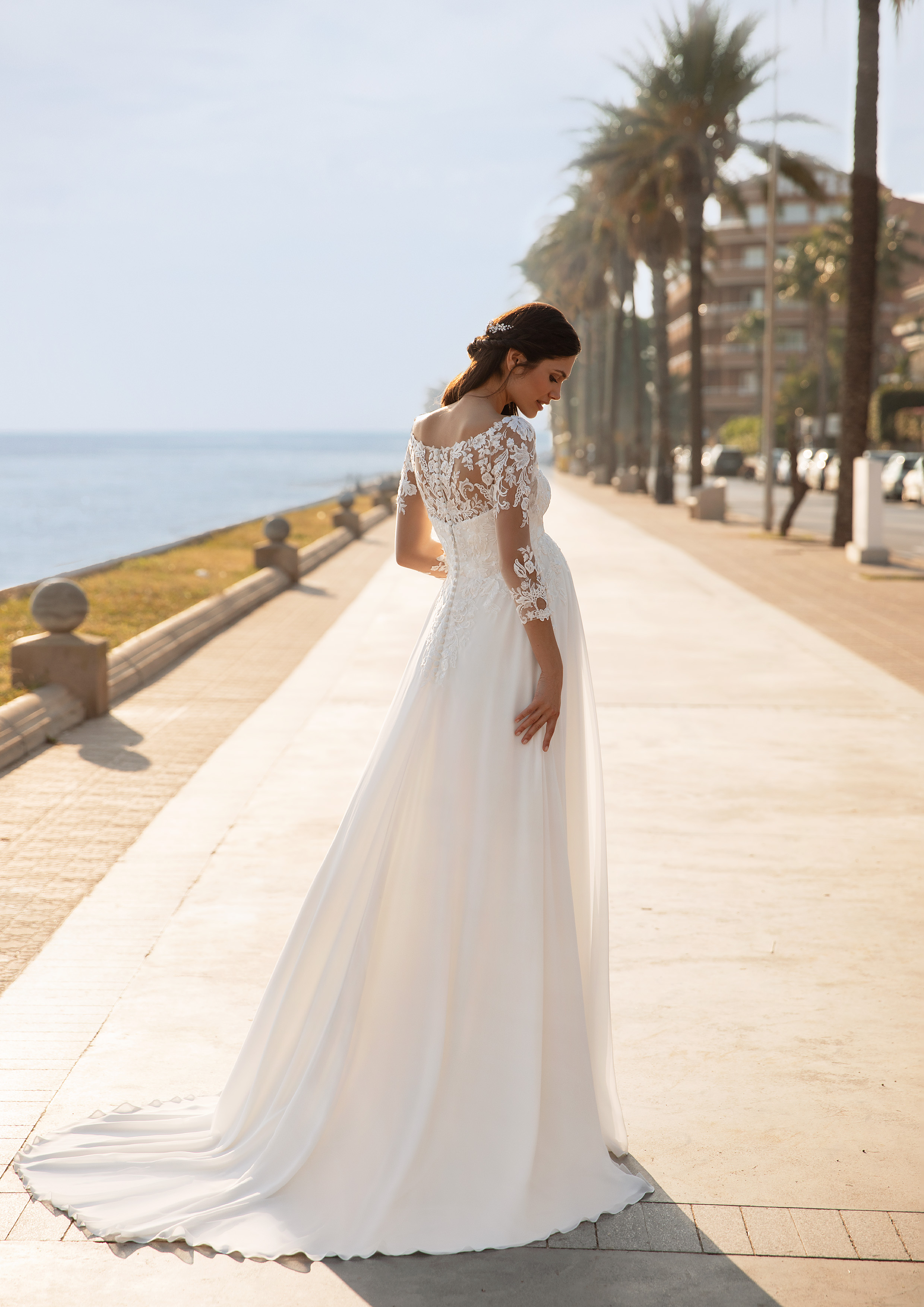 Vestido de noiva da linha maternidade com decote coração sobreposição em tule transparente com aplicações florais de decote barco e manga comprida | Modelo Lucky Star da coleção Cápsula Maternidade Pronovias 2021 Cruise Collection