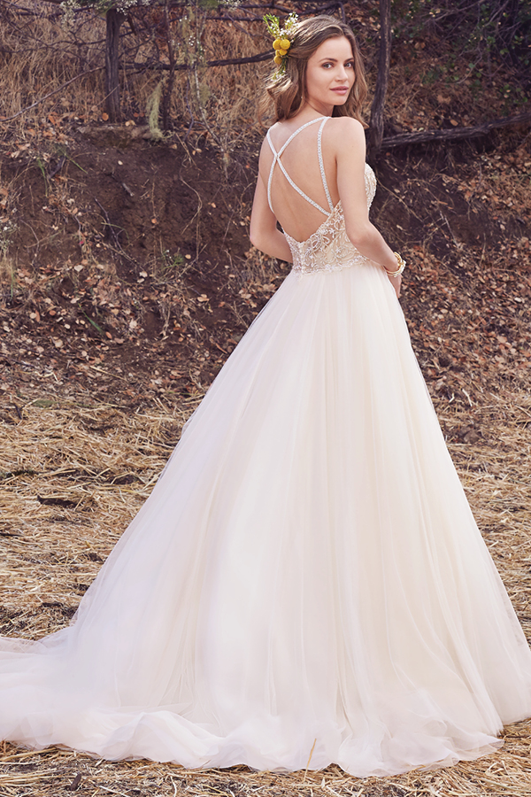 Este vestido de noiva encantador apresenta um corpete cuja beleza é realçada com bordados sobre uma volumosa saia de tule. Alças finas deslizam desde o decote em forma de coração até a um decote em forma de U nas costas. Terminado com botões de cristal na zona do fecho.