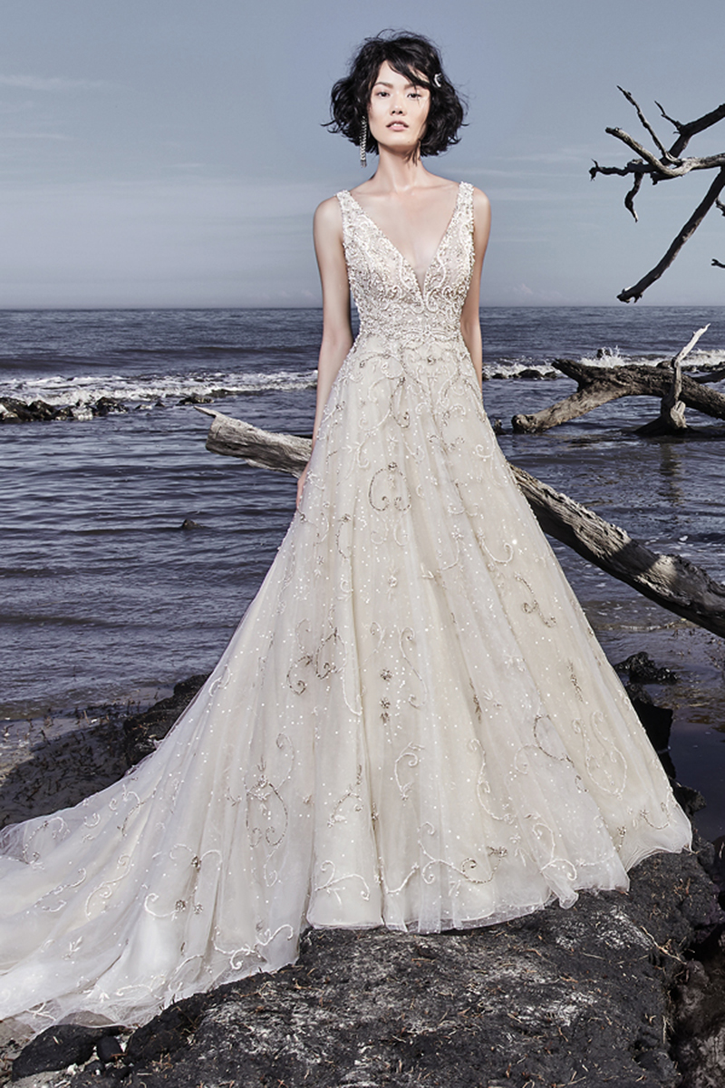 Bordados e cristais Swarovski dançam ao longo do maravilhoso tule que confeciona este vestido de noiva. Um decote em V, embelezado com alças e um decote quadrado na parte das costas confere um glamour extremamente sofisticado a este vestido de noiva. Terminado com botões de cristal e, ainda, um fecho.
<a href="https://www.maggiesottero.com/sottero-and-midgley/maven/11556">Sottero and Midgley</a>