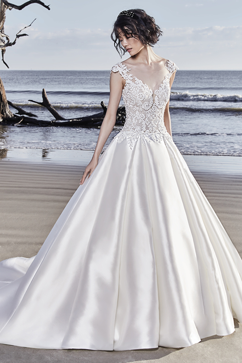 Fabulosos detalhes motivos de renda e cristais Swarovski conferem um toque ao corpete deste vestido de noiva princesa, completando a ilusão. Saia de baile composta por Olya Mikado. Termina com botões de cristal que cobrem o fecho.
<a href="https://www.maggiesottero.com/sottero-and-midgley/huntington/11541">Sottero and Midgley</a>
