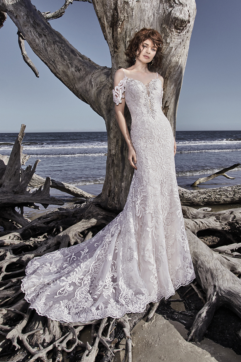 Modelos de renda bordados e cristais Swarovski dançam ao longo do tule que caracteriza este sofisticado vestido de noiva fit-and-flate. Alças finas "nascem" de um magnífico decote em forma de coração,m terminando num deslumbrante decote em U nas costas. Terminado com botões.
<a href="https://www.maggiesottero.com/sottero-and-midgley/ross/11564">Sottero and Midgley</a>