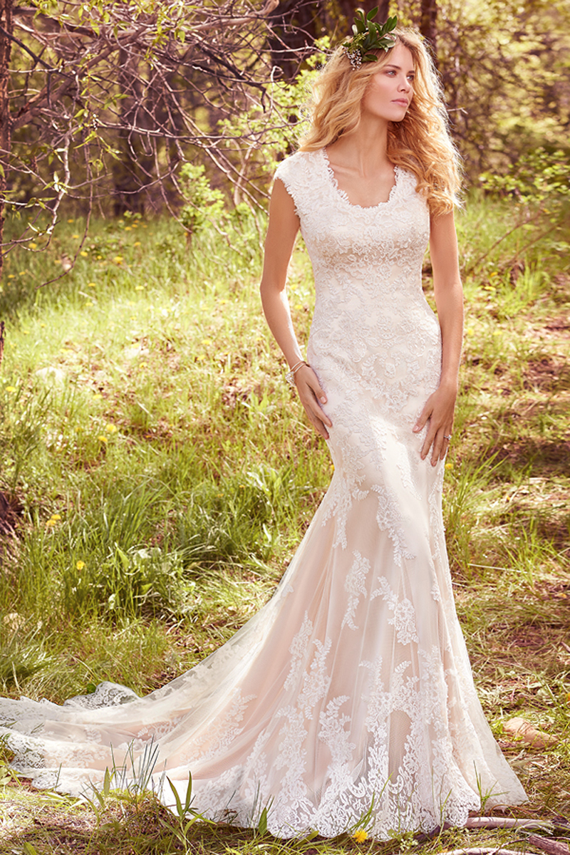 Este modesto fit-and-flare apresenta cascatas de renda acima do tule e uma camada de cetim Demir, mangas curtas e jóias no decote, bordadas com renda. Terminado com botões na zona do fecho e um elástico no interior.
<a href="https://www.maggiesottero.com/maggie-sottero/elsa/10159?utm_source=mywedding.com&utm_campaign=spring17&utm_medium=gallery" target="_blank">Maggie Sottero</a>