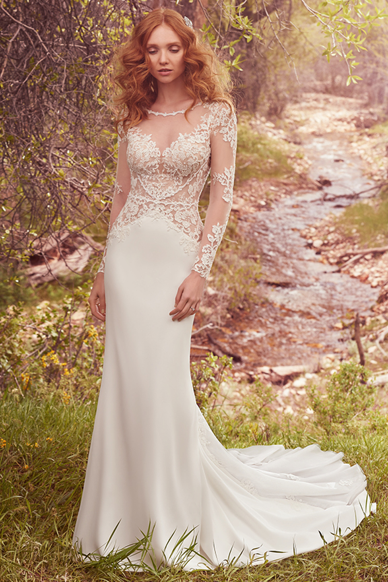 Este impressionante vestido exibe um corpete com detalhes em renda, criando um efeito de decote em forma de coração, realçando os ombros, mangas compridas. Um vestido cujos pormenores das costas evocam romance e que apresenta um “godet” que confere volume à saia. Terminado com botões e com um fecho.
<a href="https://www.maggiesottero.com/maggie-sottero/blanche/10089?utm_source=mywedding.com&utm_campaign=spring17&utm_medium=gallery" target="_blank">Maggie Sottero</a>
