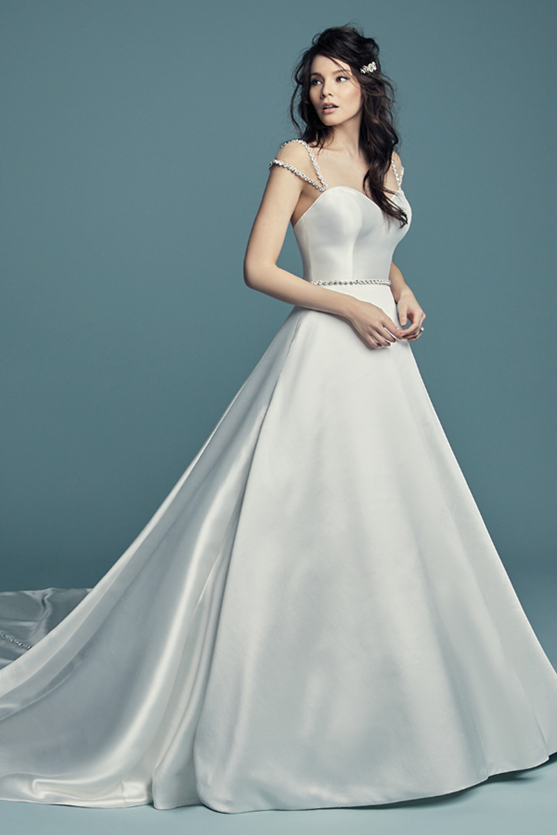 <a href="https://www.maggiesottero.com/maggie-sottero/benicia/11456
5">Maggie Sottero</a>
O vestido de noiva Keela Mikado apresenta um decote em forma de coração sem alças e uma saia graciosa com volume. Os cristais Swarovski realçama a linha coberta com botões ao longo da cauda. Terminado com botões de cristal, por cima de um fecho e um espartilho elástico interior. Cinto com cristais Swarovski vendido separadamente.