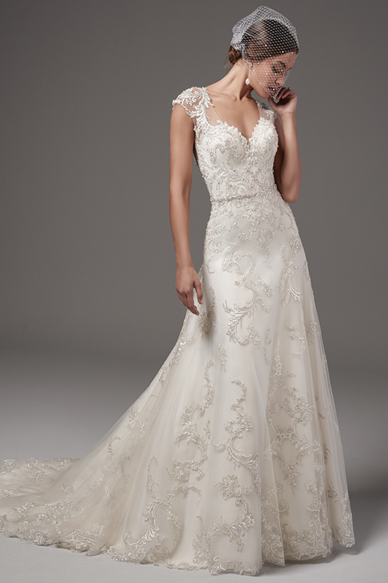 Este belíssimo vestido Linha-A é decorado e embelezado com pormenores de renda na zona do tule realçando as costas do vestido. Mangas curtas e um decote em forma de coração e um cinto com cristais Swarovski. Terminado com botões de cristal em vez do fecho.
<a href="https://www.maggiesottero.com/sottero-and-midgley/nicolette/10244?utm_source=mywedding.com&utm_campaign=spring17&utm_medium=gallery" target="_blank">Sottero and Midgley</a>