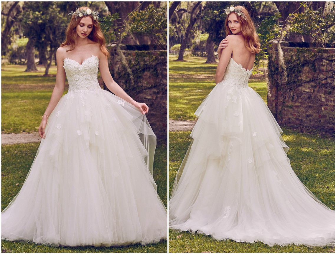 Aplicações de renda florais em 3D cobrem o corpete de decote coração deste vestido de corte princesa, que cai ligeiramente em cascata numa saia de tule volumosa. Acabamentos com botões de cristal sobre fecho zíper e fecho interior de corselete. <a href="https://www.maggiesottero.com/maggie-sottero/maura/11177?utm_source=zankyou&utm_medium=gowngallery" target="_blank">Maggie Sottero</a>