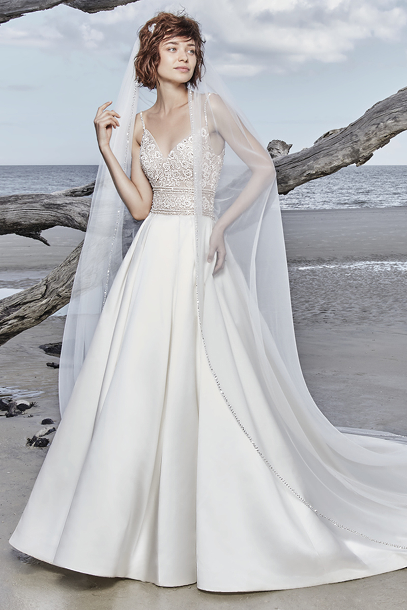 Um vestido de noiva com corte de princesa e com detalhes boho, apresenta uma renda magnífica que ganha destaque graças aos cristais Swarovski.Alças finas que vêm desde o decote em V até ao U das costas. Terminado com botões de cristais que cobrem o fecho. Véu de tule vendido separadamente.
<a href="https://www.maggiesottero.com/sottero-and-midgley/saylor/11566">Sottero and Midgley</a>