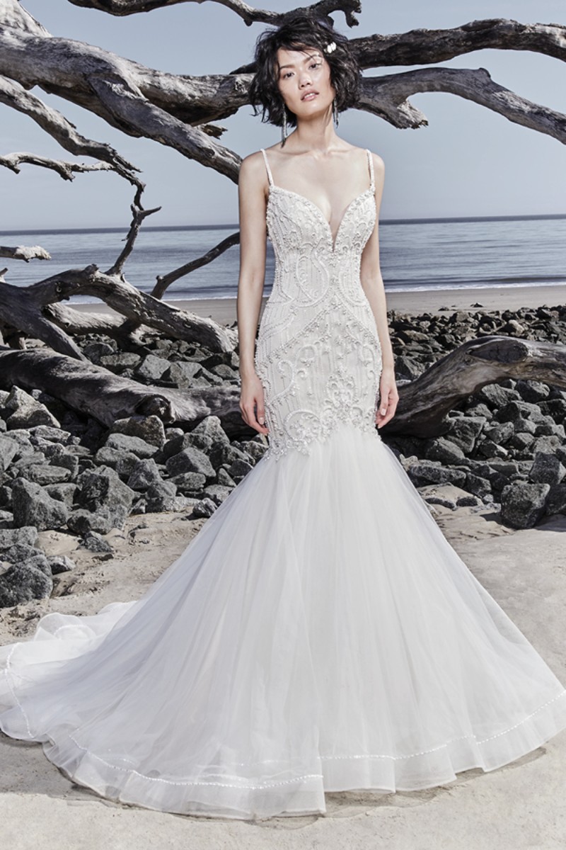 <a href="https://www.maggiesottero.com/sottero-and-midgley/nouvelle/11559">Maggie Sottero</a>
Detalhes de renda cintilantes e cristais Swarovski adornam o corpete deste vestido sexy fit-and-flare, finalizando o decote ilusão, suas finíssimas alças e o decote das costas.