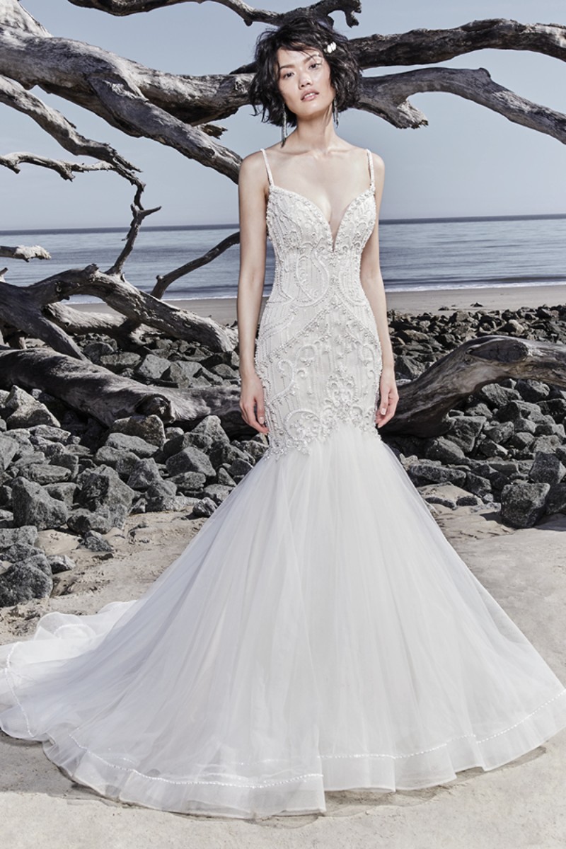 <a href="https://www.maggiesottero.com/sottero-and-midgley/nouvelle/11559">Maggie Sottero</a>

Detalhes de renda cintilantes e cristais Swarovski adornam o corpete deste vestido sexy fit-and-flare, finalizando o decote ilusão, suas finíssimas alças e o decote das costas.