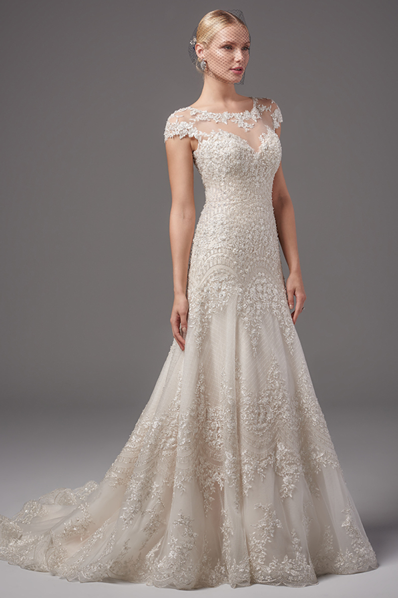 Este vestido magnificente Linha-A apresenta um padrão que embeleza os pormenores em renda e um impressionante cruzado. Um decote barco em vez em forma de coração, mangas curtas e um efeito de cascata nas costas confere toda um sensualidade e romance ao look. Terminado com botões de cristal e um fecho.
<a href="https://www.maggiesottero.com/sottero-and-midgley/gigi/10226?utm_source=mywedding.com&utm_campaign=spring17&utm_medium=gallery" target="_blank">Sottero and Midgley</a>