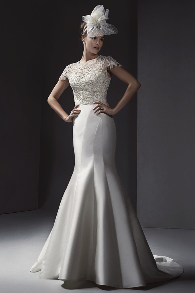 Vestido de noiva sofisticada com uma forma elegante e decote romântico de coração. É opcional um casaco muito luxuoso. Acabamento com coberta de botões no zíper e fecho elástico interior.
<a href="http://www.sotteroandmidgley.com/dress.aspx?style=5SW136" target="_blank">Sottero and Midgley Spring 2015</a>