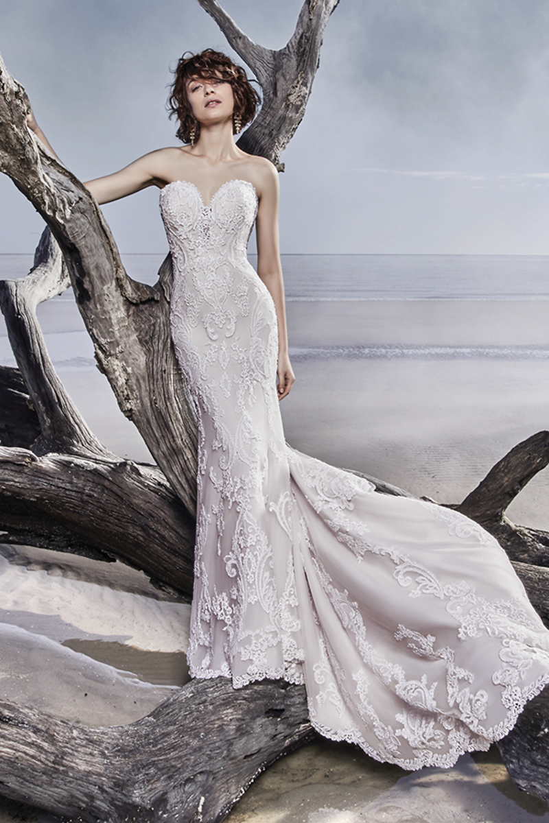 Este maravilhoso vestido de noiva fit-and-flare de tule apresenta pormenores de renda, acentuados com bordados e lantejoulas. Terminado com costas de ilusão, recortes e um decota em forma de coração - todos estes elementos apresetam pormenores de renda. Terminado com botoes de cristal sobre um fecho.
<a href="https://www.maggiesottero.com/sottero-and-midgley/memphis/11557">Sottero and Midgley</a>