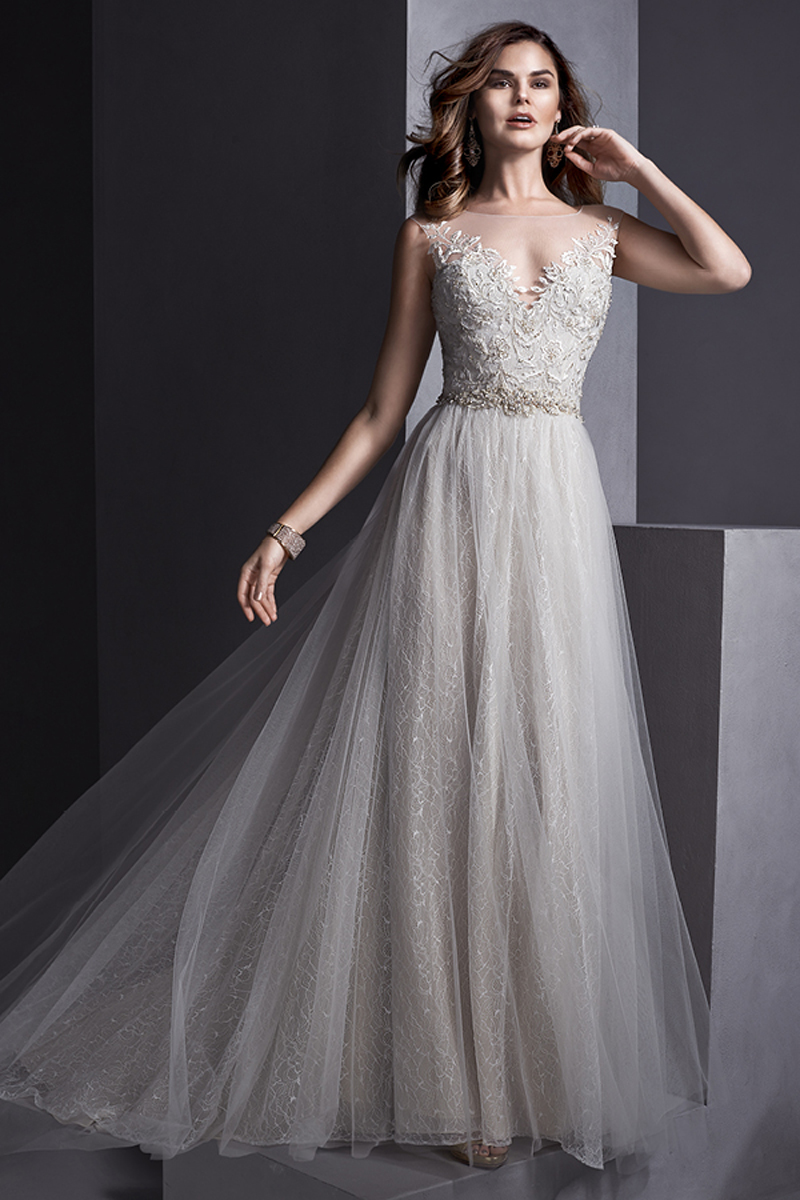 Um tule que flui harmoniosamente sobre uma renda romântica criam este vestido com um deslumbrante decote ilusão com pormenores de renda. Um cinto com cristais Swarovski que realça a cintura da noiva. Terminado com botões de cristal em vez de um fecho.
<a href="http://www.sotteroandmidgley.com/dress.aspx?style=5SR104&page=0&pageSize=36&keywordText=&keywordType=All" target="_blank">Sottero and Midgley</a>