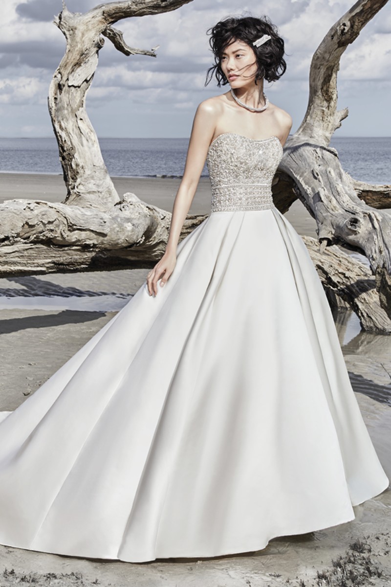 <a href="https://www.maggiesottero.com/sottero-and-midgley/phoenix/11561">Maggie Sottero</a>

Um elegante vestido princesa com toques únicos, esta peça Carlo Satin apresenta um corpete de bordados com contas e cristais Swarovski.