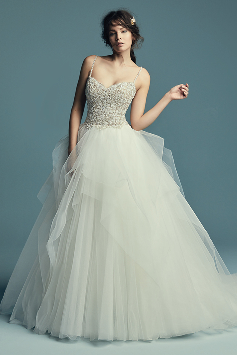 <a href="https://www.maggiesottero.com/maggie-sottero/shauna/11505">Maggie Sottero</a>

Este elegante vestido de noiva apresenta um body com cristais Swarovski sobre uma saia de tule. Decote em forma de coração bastante subtil com alças finas. Terminado com botõe sobre um fecho. 