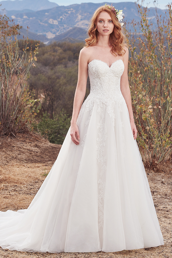 Este magnífico vestido de noiva sem alças apresenta um corpete com renda bordada, ao mesmo tempo que pormenores de renda caem ao longo do tule que constitui a saia. Um look completo com um decote em forma de coração. Terminado com botões na zona do fecho e um espartilho no interior. Mangas curtas vendidas separadamente.
