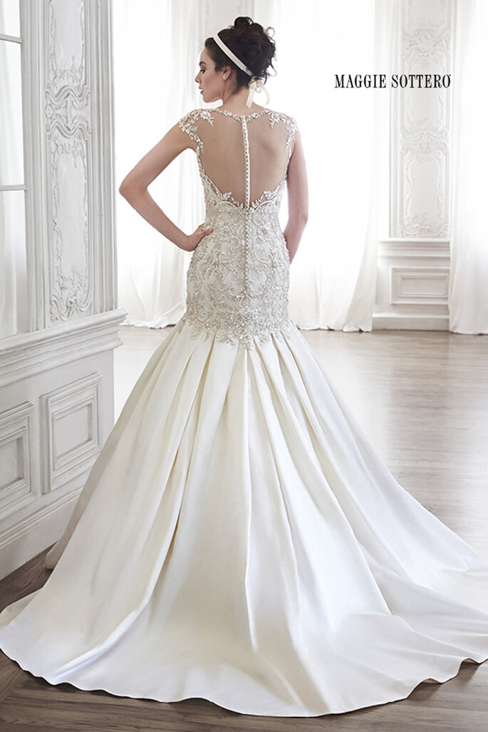 Os cristais Swarovski enfeitam a parte superior deste romântico vestido e os ombros acentuam-se com malha ilusão que cobre todas as costas até à cintura. O decote coração clássico completam o look deste vestido de cetim suave.
<a href="http://www.maggiesottero.com/dress.aspx?style=5MR094" target="_blank">Maggie Sottero Spring 2015</a>