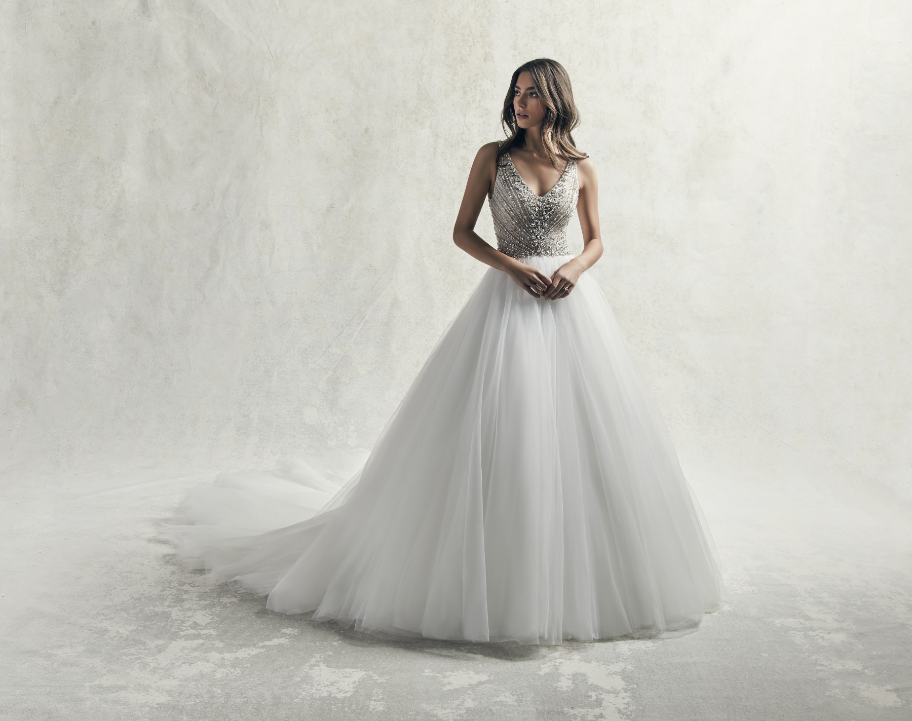 Este vestido de noiva com influências vintage apresenta um body com missangas puras, acentuadas com cristais Swarovski e padrões geométricos. Apresenta, ainda, alças, um decote em V e em U nas costas.