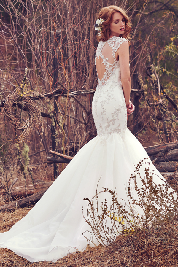 Pormenores de renda brilhantes com pérolas e cristais Swarovski decoram o corpete deste encantador vestido fit-and-flare que combinam com o decote em forma de U e saia organza Venice. Mangas curtas com efeio ilusão oferecem um glamour suave a este look. Terminado com botões de cristal na zona do fecho.
