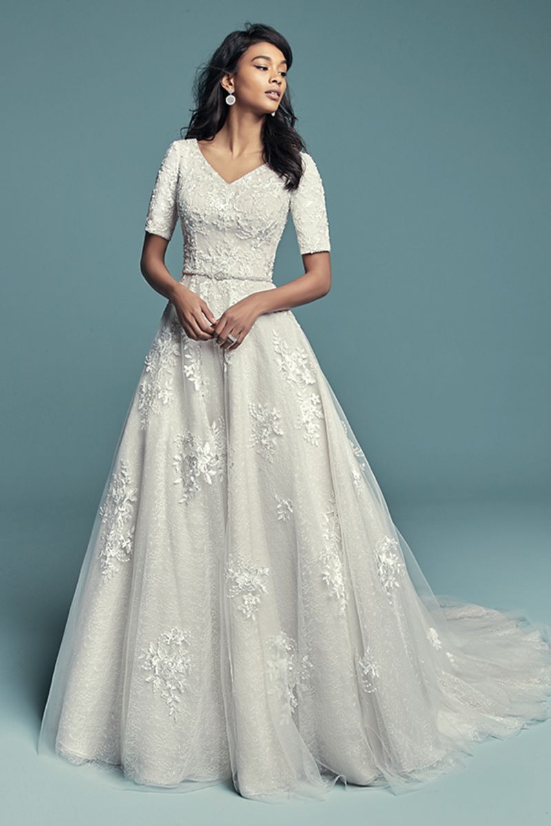 <a href="https://www.maggiesottero.com/maggie-sottero/meryl-marie/11497">Maggie Sottero</a>
Este vestido modesmo mas elegante apresenta várias camadas de tulee Organza Chic. Para além disso, apresenta um decote em V e mangas meio-quarto. Terminado com botões cobertos sobre um fecho e um espartilho interior elástico. Cinto removível com cristais Swarovski vendidos separadamente.