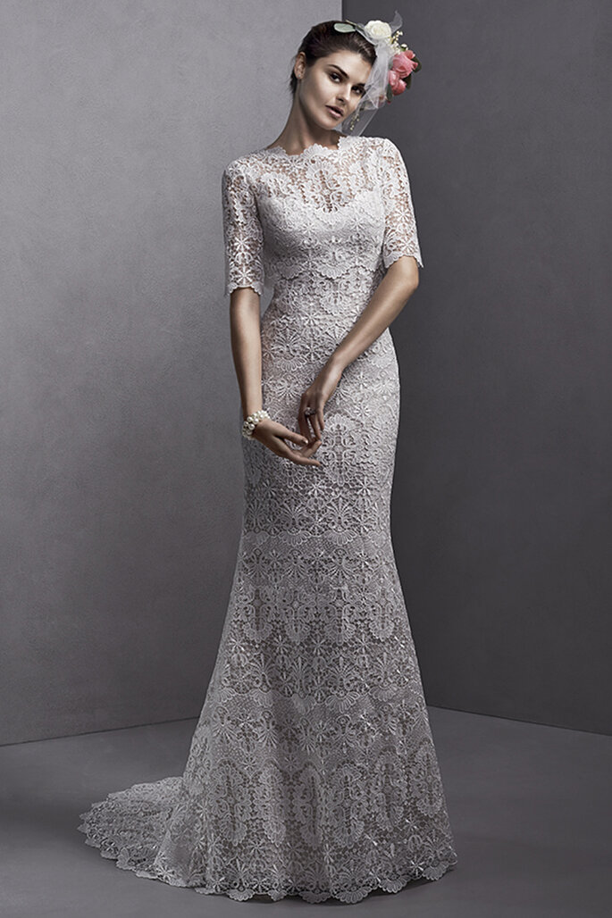 Vestido de noiva de renda elaborado, com alças e opção de combinar com casaco de renda com mangas. Acabamento de coberta de botões sobre o zíper.
<a href="http://www.sotteroandmidgley.com/dress.aspx?style=5SS095" target="_blank">Sottero and Midgley Spring 2015</a>