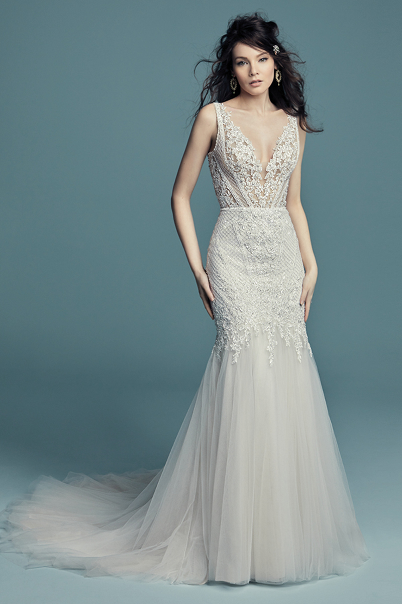 <a href="https://www.maggiesottero.com/maggie-sottero/tanner-lynette/11508">Maggie Sottero</a>
Este ímpar vestido de noiva inspirado em num estilo vintage apresenta um body com pormenores de renda bordados. Alças surgem de um profundo decote com efeito ilusão, enquanto que nas costas, podemos deparar-nos com uma abertura em forma de U. Terminado com botões cobertos sobre um fecho.
