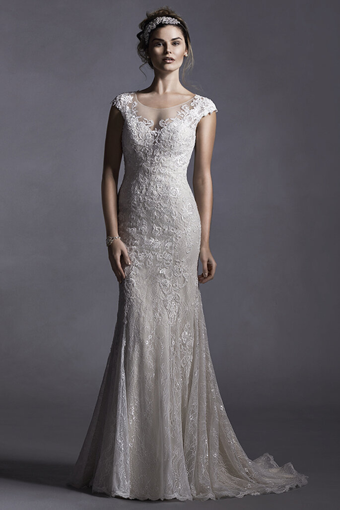 Vestido de noiva glamuroso com aplicações de renda que enfeitam o tule. Um modelo de tubo com mangas de renda delicada e coberta de botões sobre o zíper.
<a href="http://www.sotteroandmidgley.com/dress.aspx?style=5SS025" target="_blank">Sottero and Midgley Spring 2015</a>