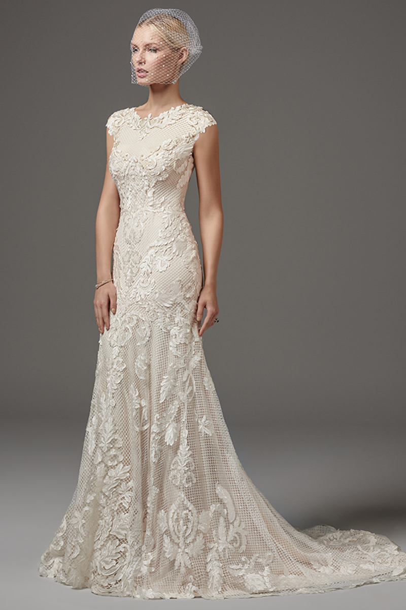 Este fit-and-flare ímpar com renda cortada a laser apresenta um decote com jóias e mangas subtis com pormenores de renda. Terminado com fecho.
<a href="https://www.maggiesottero.com/sottero-and-midgley/suzanne-rose/10253?utm_source=mywedding.com&utm_campaign=spring17&utm_medium=gallery" target="_blank">Sottero and Midgley</a>