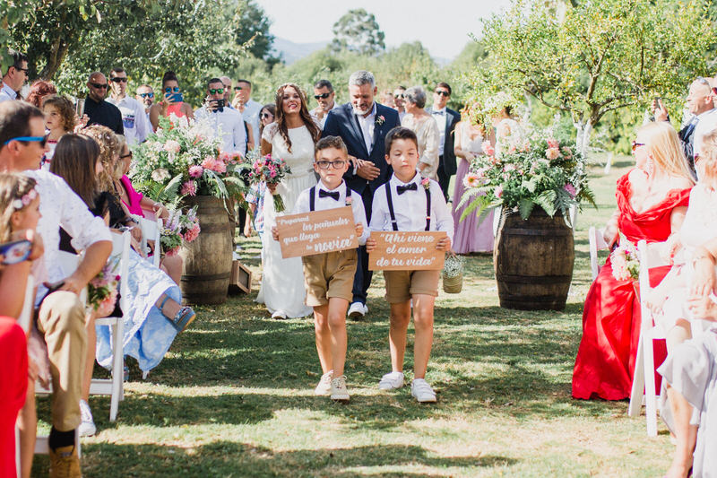 entrada da noiva pajens com placas com bermudas e laço