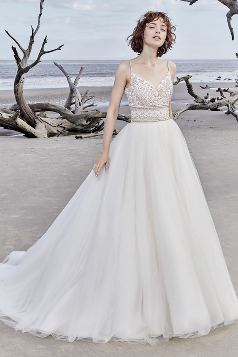 Um vestido de noiva com corte de princesa e com detalhes boho, apresenta uma renda magnífica que ganha destaque graças aos cristais Swarovski.Alças finas que vêm desde o decote em V até ao U das costas. Terminado com botões de cristais que cobrem o fecho. Véu de tule vendido separadamente.
<a href="https://www.maggiesottero.com/sottero-and-midgley/saylor-rose/11568">Sottero and Midgley</a>