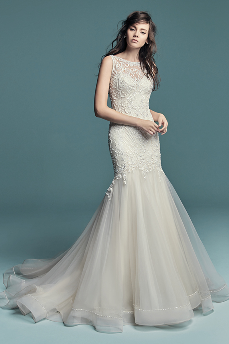 <a href="https://www.maggiesottero.com/maggie-sottero/ariella/11273">Maggie Sottero</a>

Este vestido de noiva inspirado num estilo mais vintage apresenta um corpete com pormenores de renda bordados, realçados por pérolas e cristais Swarovski, caindo em cascata ao longo da saia de tule. Alças extremamente finas duplas nascem do profundo decote das costas, terminando num decote halter. Terminado com botões cobertos e um fecho. Véu de tule vendido separadamente. 
