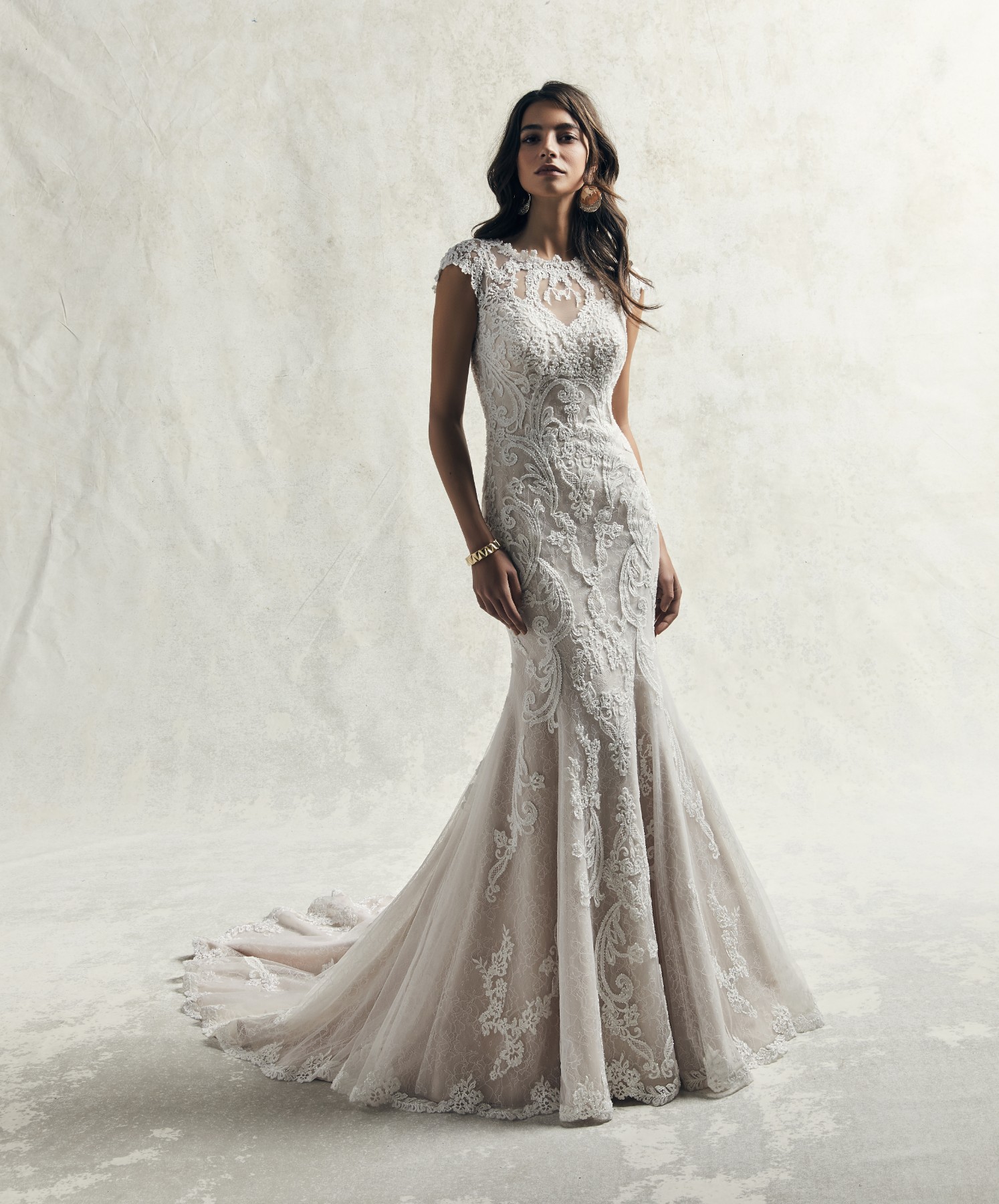 Beaded lace motifs dance over an all over lace and textured tulle in this vintage-inspired sheath wedding dress.
Detalhes de renda bordados dançam ao longo da renda e do tule com textura que confecionam este vestido de noiva.